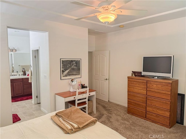 bedroom with light colored carpet, ensuite bath, a sink, and ceiling fan