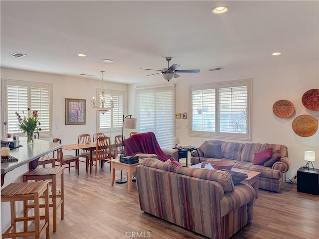 living area featuring a ceiling fan, a chandelier, light wood-type flooring, and recessed lighting