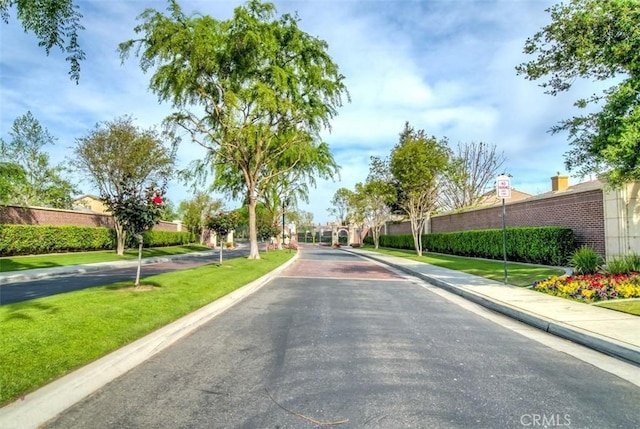 view of asphalt road with sidewalks, curbs, and traffic signs