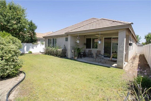back of property with ceiling fan, a tile roof, stucco siding, and a patio area