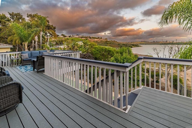 wooden terrace featuring a water view and an outdoor hangout area