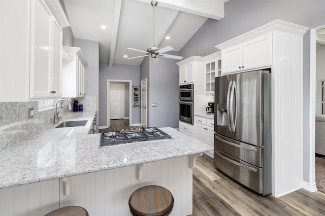 kitchen featuring stainless steel appliances, a sink, a peninsula, backsplash, and recessed lighting