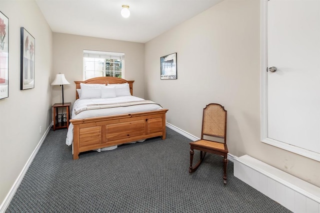 bedroom with dark carpet, baseboards, and a baseboard radiator