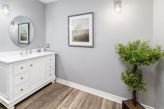 bathroom with wood finished floors, baseboards, and vanity