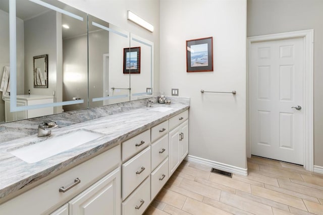 full bathroom featuring baseboards, double vanity, and wood tiled floors