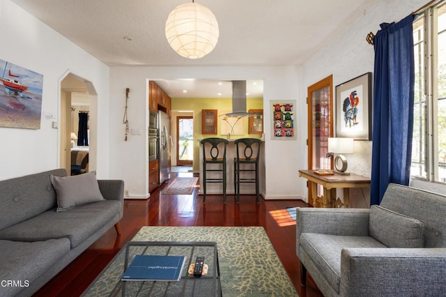 4129 Marmion Way, Los Angeles, CA 90065 - living area featuring plenty of natural light, dark wood-style floors, arched walkways, and baseboards