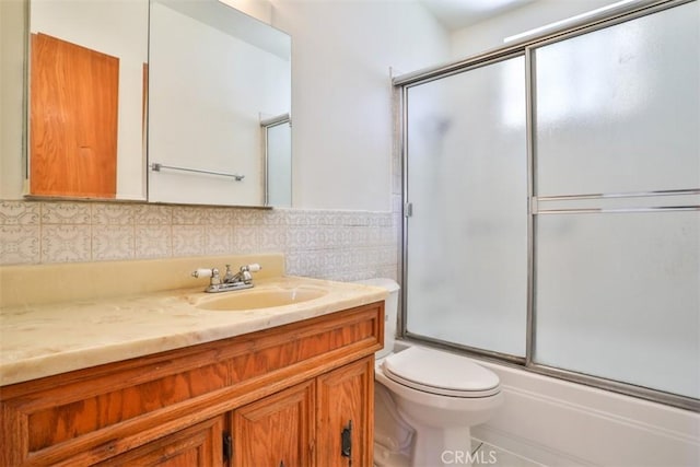 full bathroom with vanity, decorative backsplash, toilet, and enclosed tub / shower combo