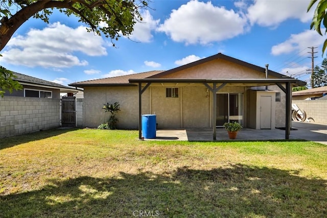 rear view of house featuring a patio area, stucco siding, and a gate