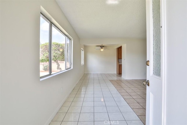 unfurnished room featuring light tile patterned flooring and a textured ceiling