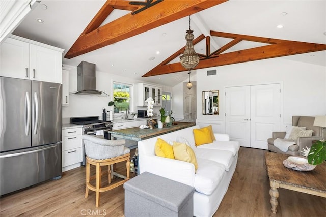 385 Mermaid, Laguna Beach, CA 92651 - kitchen featuring appliances with stainless steel finishes, wall chimney range hood, beam ceiling, wood finished floors, and white cabinets