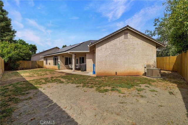 6 Vintage Ct, Chico, CA 95973 - back of house with stucco siding, central air condition unit, roof mounted solar panels, a fenced backyard, and a patio area