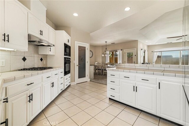 6 Vintage Ct, Chico, CA 95973 - kitchen with black appliances, tile countertops, recessed lighting, tasteful backsplash, and under cabinet range hood