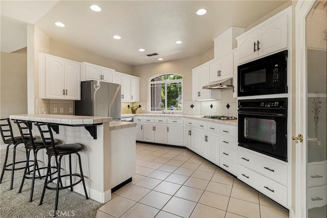 6 Vintage Ct, Chico, CA 95973 - kitchen featuring black appliances, tile countertops, a kitchen bar, a peninsula, and under cabinet range hood