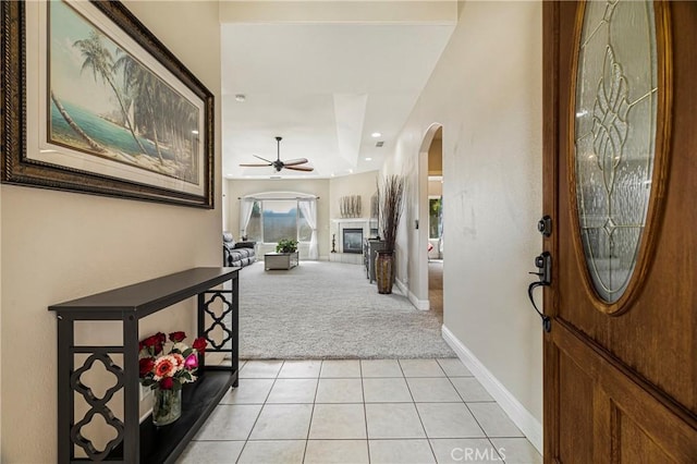 6 Vintage Ct, Chico, CA 95973 - foyer with light colored carpet, arched walkways, a ceiling fan, light tile patterned floors, and a glass covered fireplace