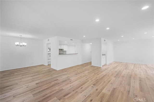 4542 Willis Ave Unit 107, Sherman Oaks, CA 91403 - unfurnished living room with a chandelier, recessed lighting, light wood-style floors, and baseboards