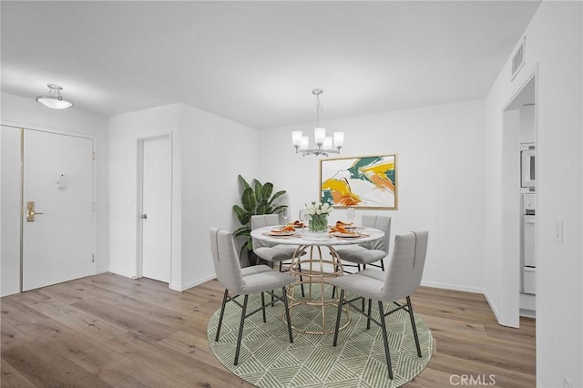4542 Willis Ave Unit 107, Sherman Oaks, CA 91403 - dining area featuring light wood-type flooring, a chandelier, and baseboards