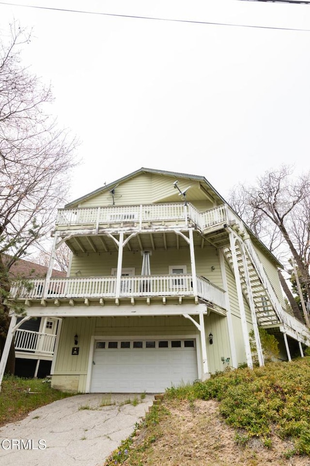 385 Spruce Dr, Lake Arrowhead, CA 92352 - view of front of house featuring a garage, driveway, and a balcony