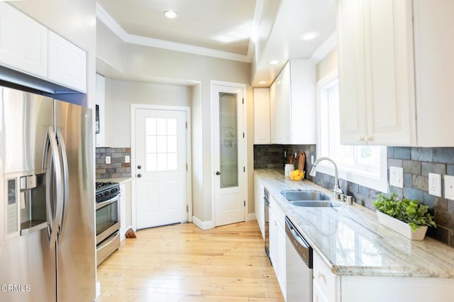 385 Spruce Dr, Lake Arrowhead, CA 92352 - kitchen with appliances with stainless steel finishes, crown molding, white cabinetry, tasteful backsplash, and light wood-style flooring