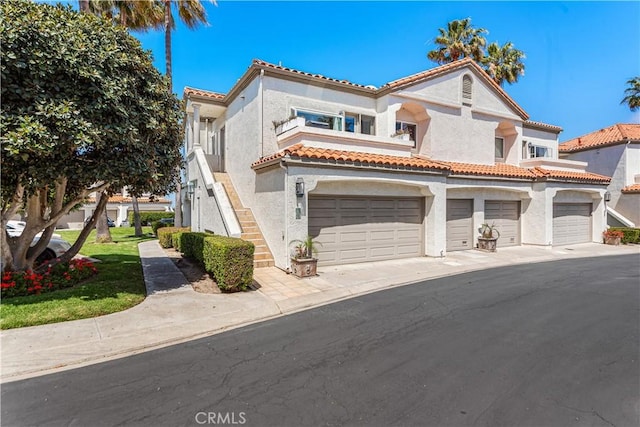 65 Centre Ct, Dana Point, CA 92629 - view of front of house featuring stucco siding, a tile roof, a garage, and stairs