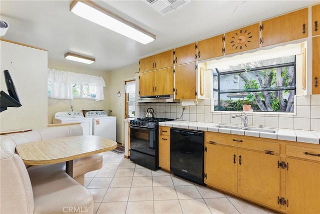 16520 Simonds St, Granada Hills, CA 91344 - kitchen featuring black appliances, washing machine and dryer, a sink, decorative backsplash, and light tile patterned floors