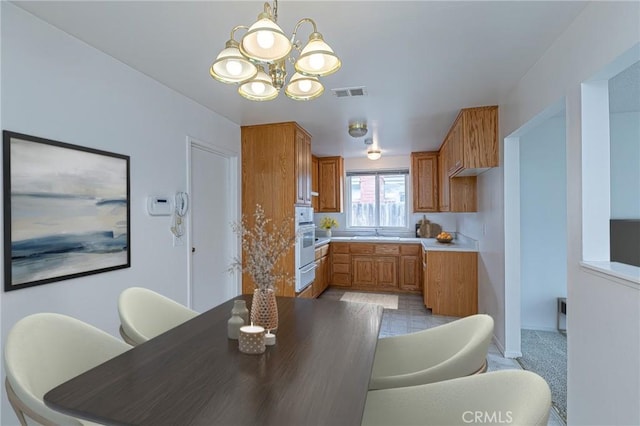 1012 W Lime Ave, Lompoc, CA 93436 - kitchen featuring a warming drawer, a sink, a chandelier, brown cabinets, and white oven