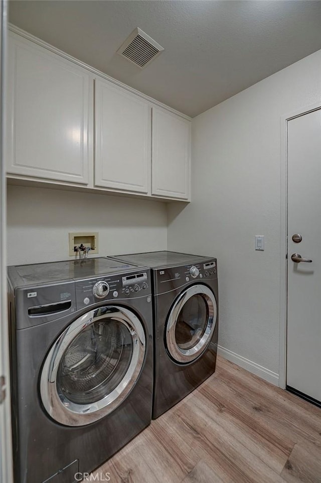 2643 Dietrich Dr, Tustin, CA 92782 - washroom with separate washer and dryer, cabinet space, light wood-style flooring, and baseboards