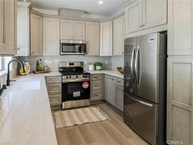 619 E Walnut, Monrovia, CA 91016 - kitchen featuring appliances with stainless steel finishes, a sink, light wood finished floors, decorative backsplash, and recessed lighting