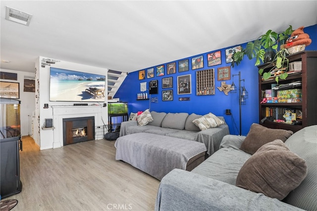 21814 Belshire Ave Unit 2, Hawaiian Gardens, CA 90716 - living room featuring wood finished floors and a lit fireplace
