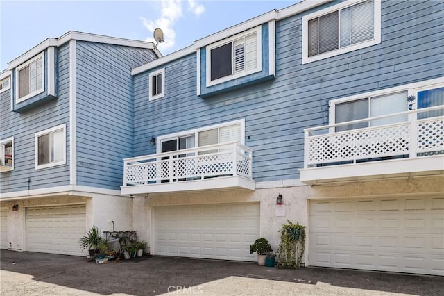 21814 Belshire Ave Unit 2, Hawaiian Gardens, CA 90716 - view of front facade with a balcony, a garage, and stucco siding