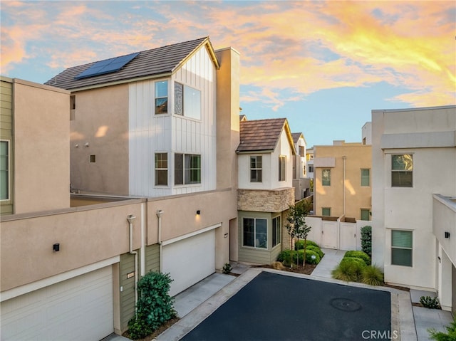 196 Episode, Irvine, CA 92618 - view of front of house with an attached garage, asphalt driveway, a gate, board and batten siding, and stone siding