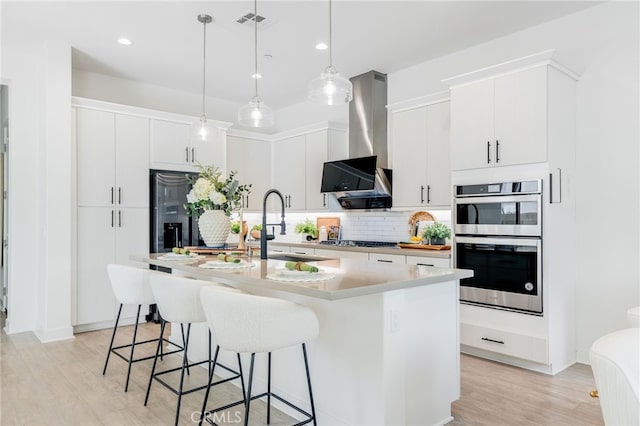 196 Episode, Irvine, CA 92618 - kitchen with appliances with stainless steel finishes, light wood-style flooring, tasteful backsplash, a kitchen breakfast bar, and a sink