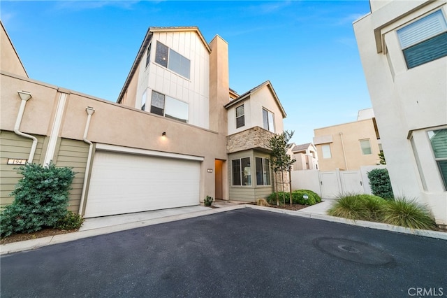 196 Episode, Irvine, CA 92618 - view of front of house featuring asphalt driveway, stucco siding, an attached garage, and board and batten siding