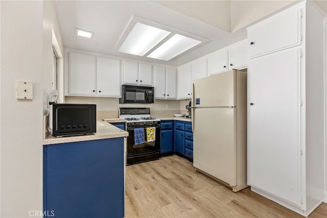 6249 Firestone Cir, Banning, CA 92220 - kitchen featuring freestanding refrigerator, range with gas stovetop, black microwave, blue cabinetry, and light wood-style flooring