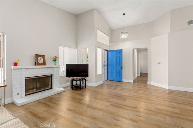 6249 Firestone Cir, Banning, CA 92220 - foyer with high vaulted ceiling, wood finished floors, a brick fireplace, and baseboards