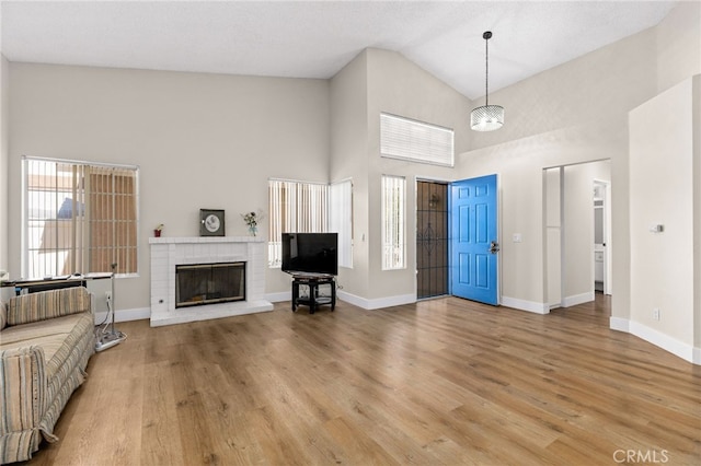 6249 Firestone Cir, Banning, CA 92220 - entrance foyer featuring high vaulted ceiling, light wood-style floors, baseboards, and a fireplace