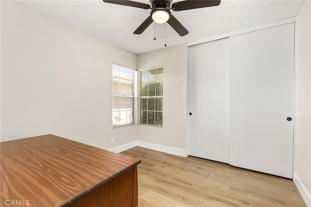 6249 Firestone Cir, Banning, CA 92220 - unfurnished office featuring light wood-style floors, baseboards, a ceiling fan, and a textured ceiling