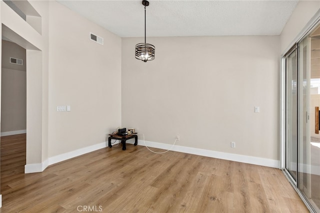 6249 Firestone Cir, Banning, CA 92220 - unfurnished dining area featuring light wood-style floors, baseboards, a chandelier, and a textured ceiling