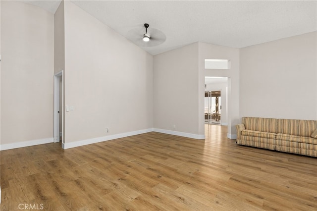 6249 Firestone Cir, Banning, CA 92220 - unfurnished living room featuring high vaulted ceiling, light wood-style flooring, baseboards, and a ceiling fan