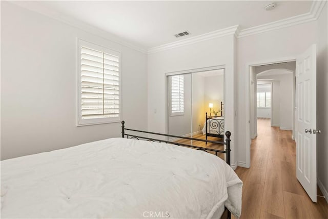 23911 Brio Ct, Valencia, CA 91354 - bedroom with crown molding, arched walkways, light wood-style floors, baseboards, and a closet