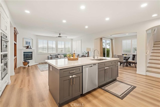 23911 Brio Ct, Valencia, CA 91354 - kitchen featuring stainless steel appliances, a sink, gray cabinetry, arched walkways, and recessed lighting