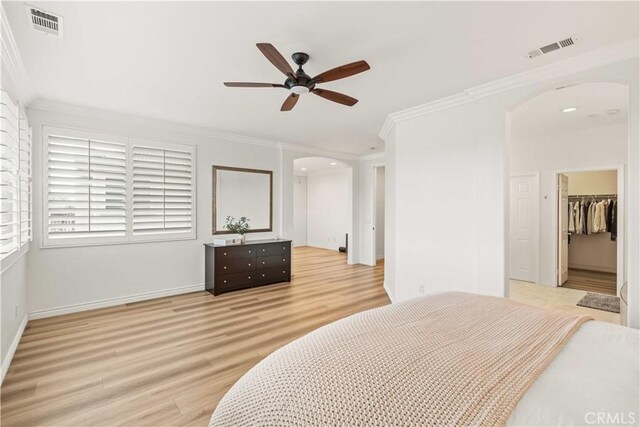 23911 Brio Ct, Valencia, CA 91354 - bedroom featuring arched walkways, crown molding, light wood-type flooring, a spacious closet, and a closet