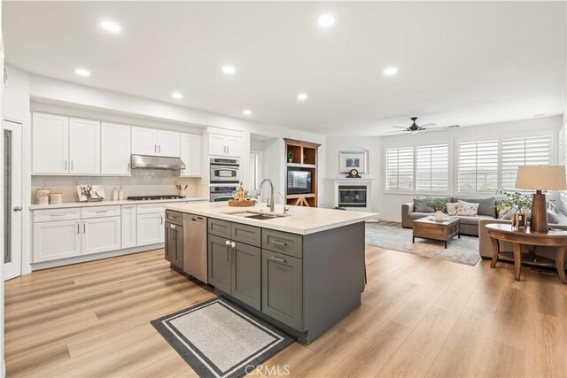 23911 Brio Ct, Valencia, CA 91354 - kitchen featuring under cabinet range hood, dishwasher, white cabinets, a sink, and recessed lighting