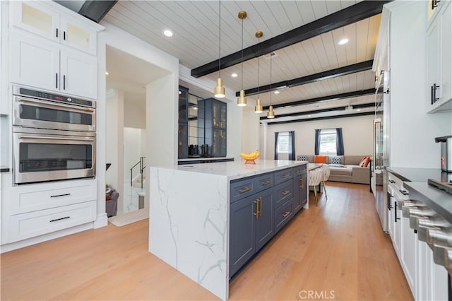 451 Avenida Esplendor, Walnut, CA 91789 - kitchen with blue cabinets, stainless steel double oven, open floor plan, beam ceiling, and light wood-style floors