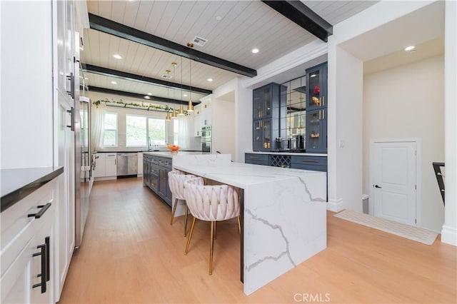 451 Avenida Esplendor, Walnut, CA 91789 - kitchen with stainless steel appliances, light wood-type flooring, beam ceiling, a large island, and a kitchen breakfast bar
