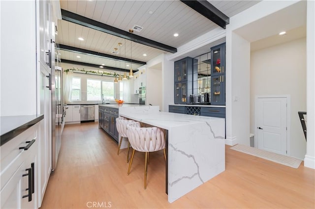 451 Avenida Esplendor, Walnut, CA 91789 - kitchen featuring appliances with stainless steel finishes, light wood-style floors, a large island, a kitchen breakfast bar, and light stone counters
