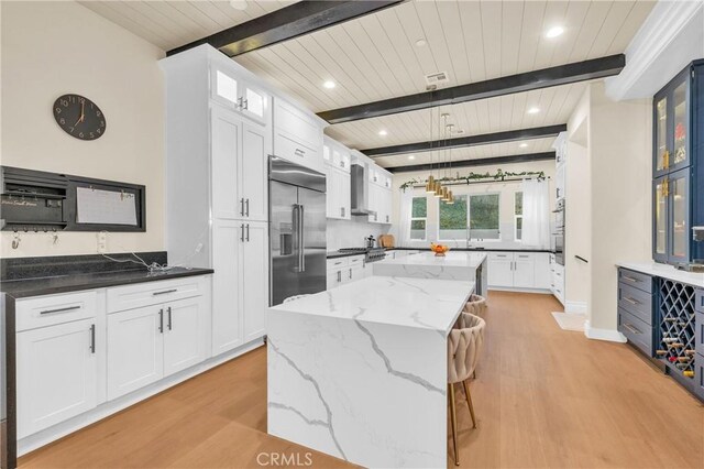451 Avenida Esplendor, Walnut, CA 91789 - kitchen with built in fridge, light wood finished floors, wooden ceiling with exposed beams, a kitchen island, and white cabinetry