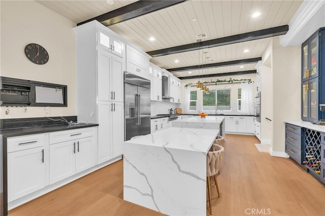 451 Avenida Esplendor, Walnut, CA 91789 - kitchen featuring appliances with stainless steel finishes, light wood-style flooring, a wood ceiling with exposed beams, a center island, and white cabinets