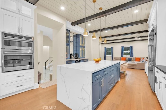 451 Avenida Esplendor, Walnut, CA 91789 - kitchen featuring blue cabinetry, light wood-type flooring, open floor plan, wood ceiling with exposed beams, and stainless steel double oven