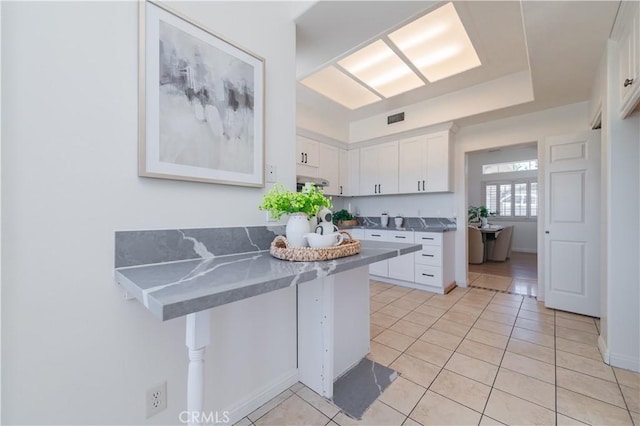 338 Calle Vis, Walnut, CA 91789 - kitchen featuring white cabinetry, light tile patterned floors, a peninsula, and a breakfast bar area
