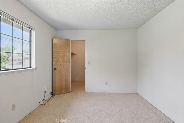442 R St, Merced, CA 95341 - unfurnished bedroom featuring carpet floors, a walk in closet, and a textured ceiling